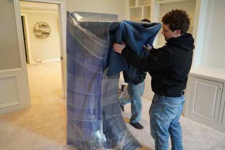A mover from Indianapolis moving company, Move Indy, pads and wraps a customer's furniture.