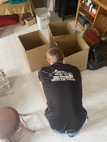Local Indianapolis mover from Move Indy labels a box after finishing packing it.